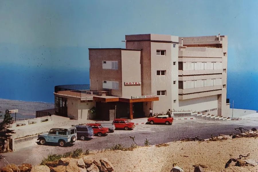Historische Aufnahme des Hotels in den Sechzigern, mit Oldtimern auf dem Vorplatz und dem Meer im Hintergrund
